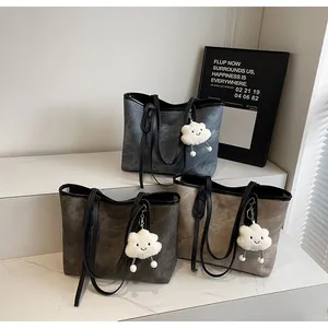 Three stylish textured tote bags with black handles and cute plush cloud charms detail