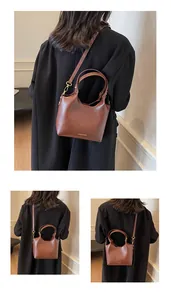 Détail d'un sac cabas marron vintage avec texture cuir et ferrures dorées