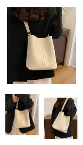 Detailed close-up of cream-white lychee grain PU leather bucket bag with wide strap