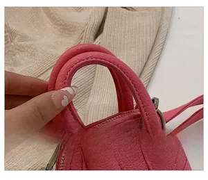 Nahaufnahme der rosa Handtasche aus Litschileder mit Doppelgriffen und Metall-Reißverschluss