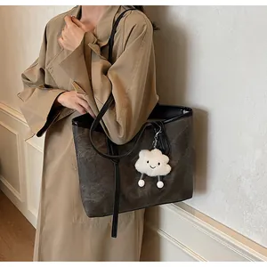 Fashionable large capacity tote bag with marble texture and plush cloud charm on model
