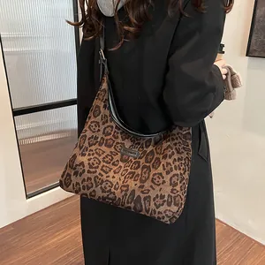 Large leopard print tote bag with black leather straps shown on model for autumn fashion