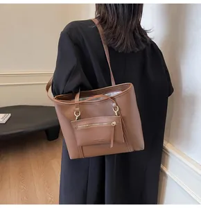 Detalle del bolso tote de cuero sintético marrón con pequeña bolsa y herrajes dorados