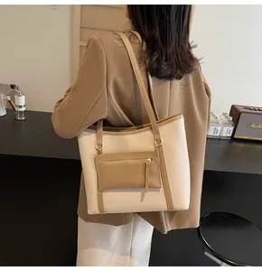 Detalle del bolso tote bicolor crema y marrón con estuche extraíble y correa fina
