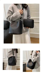 Detail of black pebbled leather bucket bag and matching zipper pouch set with gold hardware