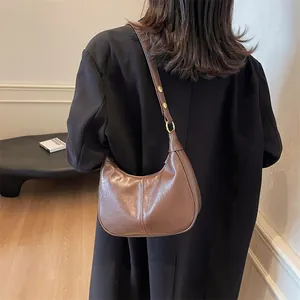 Vintage brown crescent underarm bag with adjustable strap and textured faux leather finish