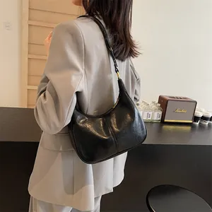 Retro black leather crescent underarm bag with adjustable strap shown on model