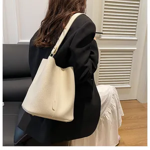 Detail showing the lychee grain texture and metal feet of this cream bucket bag