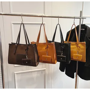 Detail of four matte suede tote bags in various colors with matching small pouches