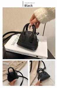 Detailansicht der mini schwarzen Tasche aus Kieselleder mit Griffen und Umhängeriemen