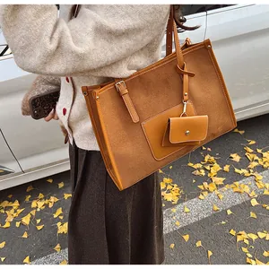 Brown suede leather tote bag detail with side pocket and hanging wallet accessory