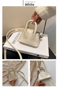 Detail der weißen Mini-Muscheltasche aus PU-Leder mit Lychee-Muster und Silberschnallen