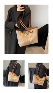 Detail of contrast stitching on beige marble texture tote bag with triangular metal plaque