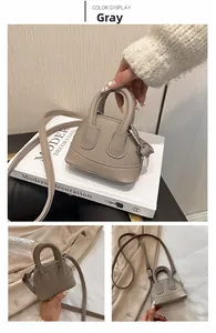 Details der grauen Mini-Muscheltasche mit Litschi-Maserung und Umhängeriemen