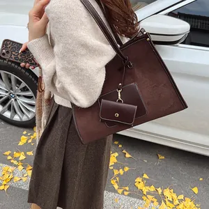 Brown faux suede tote bag with white stitching and coin purse in autumn outdoor setting