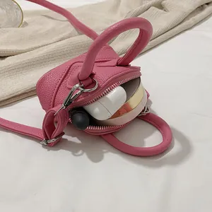 Mini-Umhängetasche in Rosa mit Litschi-Muster, zeigt Platz für Lippenstift und Kopfhörer