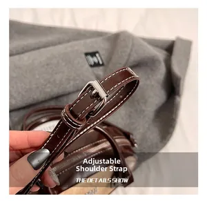 Macro shot of adjustable leather shoulder strap with silver buckle on brown bowling bag