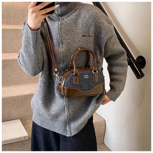 Detail of retro bowling bag showing contrasting brown faux leather and blue denim patchwork