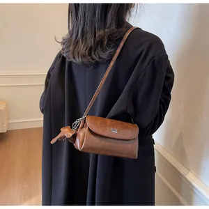 Détails du sac bandoulière vintage en cuir marron avec charme éléphant et logo