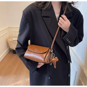 Détails du sac en cuir marron avec logo argenté et charmant pendentif éléphant