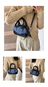 Detail view of mini bowling bag in blue denim and black patent leather with crossbody strap