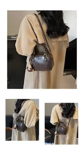 Detail of dark brown Boston bag with brand embossing and cute plush charm accessory
