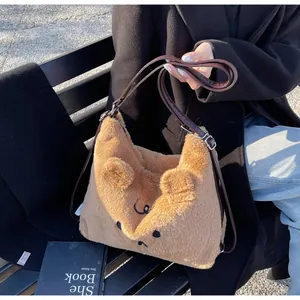 Close-up of caramel fleece teddy bear bag with adjustable leather strap on a bench