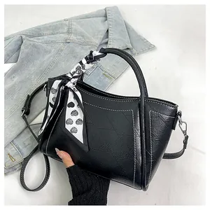 Detail of black wrinkled leather bucket bag with contrast stitching and heart silk scarf