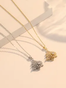 Detailed macro view of rotating snowflake and sparkling Christmas tree pendant on fine chain