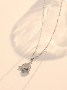 Macro detail of rotating snowflake Christmas tree necklace with sparkling zircon pavé
