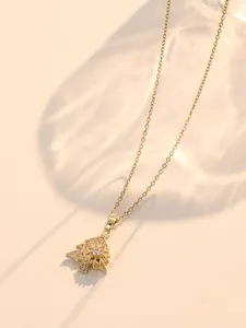 Detailed view of rotating Christmas tree pendant with shimmering crystals on gold chain