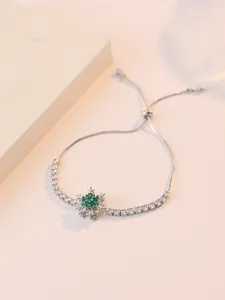 Dettaglio di un bracciale a fiocco di neve regolabile con pietre verdi e zirconi cubici