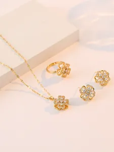 Detailansicht des goldenen Schmucksets mit funkelnden Zirkonsteinen in Kleeblattform