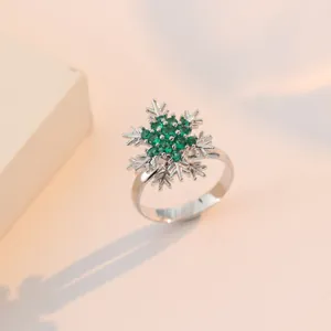 Elegante anello a fiocco di neve verde smeraldo con montatura in argento su sfondo