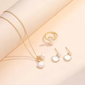 Elegant gold jewelry set with shell pendants and pearls featuring necklace, ring, and earrings