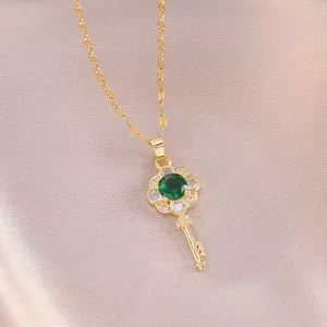 Collier clé fleur dorée élégant avec zircon émeraude sur fond en satin violet