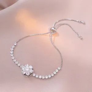 Pulsera ajustable de plata con flor de circonita sobre fondo de seda rosa suave