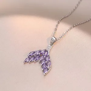 Macro shot of silver fishtail pendant with purple marquise-cut zircons and fine chain