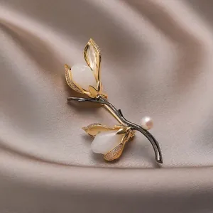 Elegante broche de magnolia con pétalos de jade blanco, perlas y cristales dorados en seda