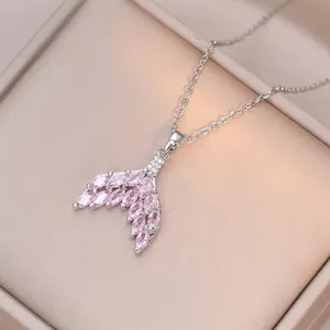 Macro detail of mermaid tail necklace with pink marquise zircons on satin jewelry box