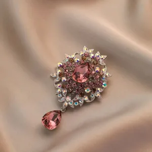 Elegant vintage floral brooch with pink gradient crystals and teardrop pendant on satin