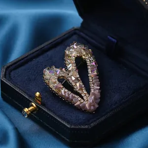 Élégante broche en forme de cœur avec zircon coloré et glands dans un écrin en velours bleu