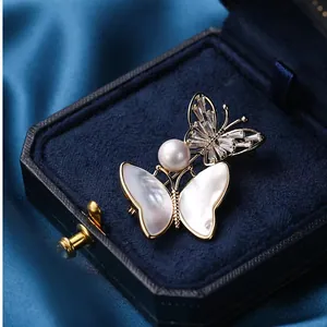 Franse vintage vlinderbroche met parelmoer en witte parel in een luxe geschenkdoos