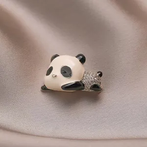 Cute panda brooch with black and white enamel and rhinestones on satin fabric
