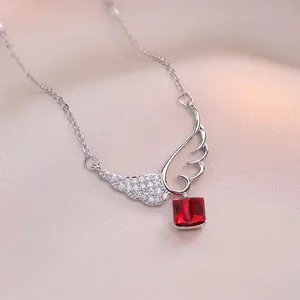 Elegant angel wing necklace with sparkling red square gemstone and tassels on champagne silk