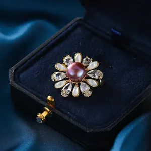 Broche fleur dorée élégante avec perle violette, nacre blanche et cristaux de zircon