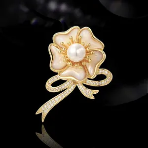 Elegante broche flor dorado con pétalos de nácar, centro de perla y base de circonitas