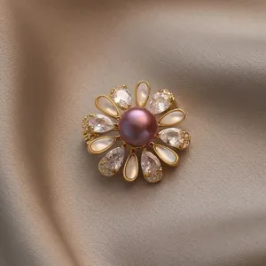 Broche élégante en or avec perle violette et pétales en nacre sur soie champagne