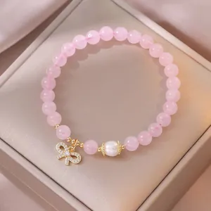 Bracciale di perle di cristallo rosa con perla d'acqua dolce e ciondolo a fiocco dorato