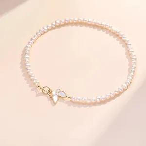 Vue détaillée du collier de perles avec pendentif papillon en nacre et fermoir OT doré
